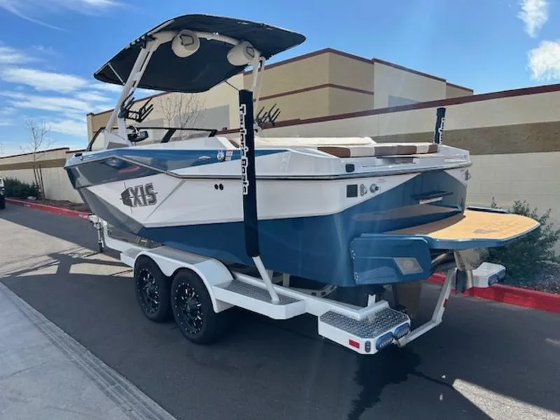 Slide: The Image of 2024 Axis T235 boat on trailer, blue and white design, parked outdoors. - 5