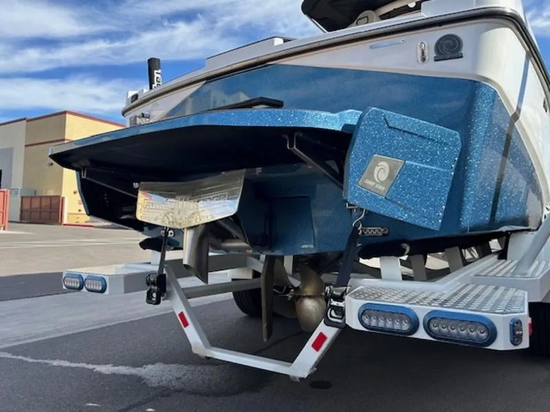 Slide: The Image of 2024 Axis T235 boat rear view with blue metallic finish and modern design. - 6