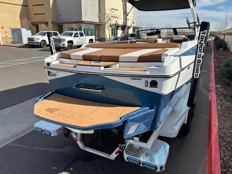 Slide: The Image of 2024 Axis T235 boat with blue and white exterior, parked near a building. - 7