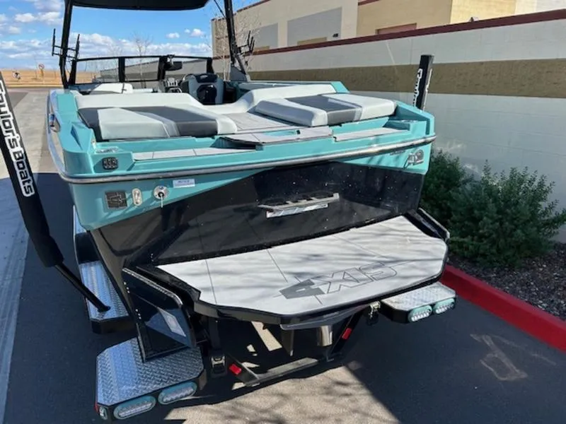 Slide: The Image of 2024 Axis T250 boat with teal and black design, parked outdoors. - 6