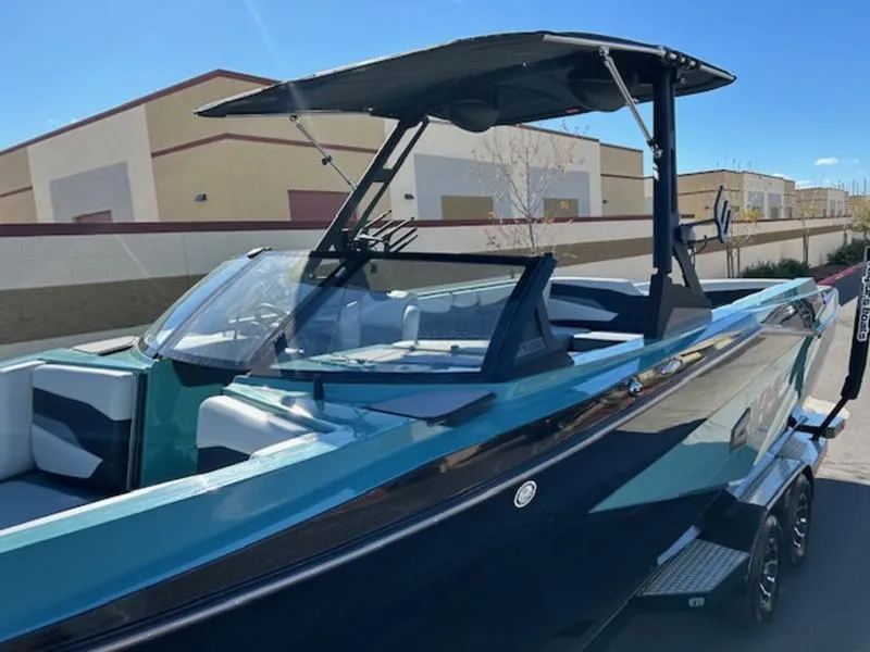 Slide: The Image of 2024 Axis T250 boat with sleek design, teal and black color, parked outdoors. - 8