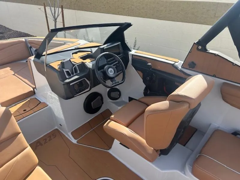 Slide: The Image of 2025 Axis A225 boat interior with tan seating and modern dashboard. - 13