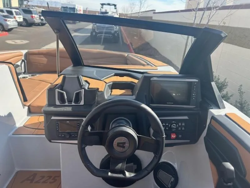 Slide: The Image of 2025 Axis A225 boat dashboard with steering wheel and navigation controls. - 14