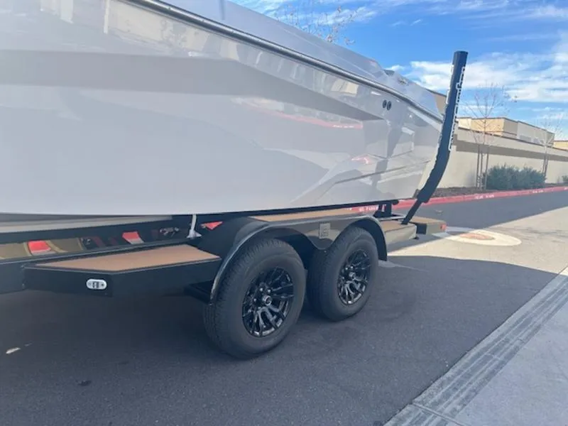 Slide: The Image of 2025 Axis A225 boat on a dual-axle trailer, parked on a street. - 7