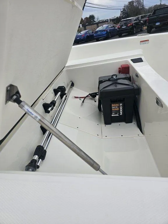 Slide: The Image of 2025 Mako Pro Skiff 15 CC storage compartment with battery and equipment. - 15