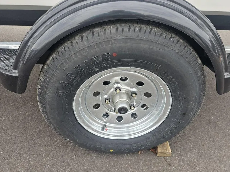 Slide: The Image of Trailer wheel of 2025 Mako Pro Skiff 15 CC on pavement. - 22
