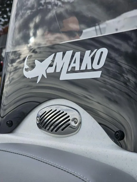 Slide: The Image of 2025 Mako Pro Skiff 15 CC boat windshield with logo and speaker detail. - 23