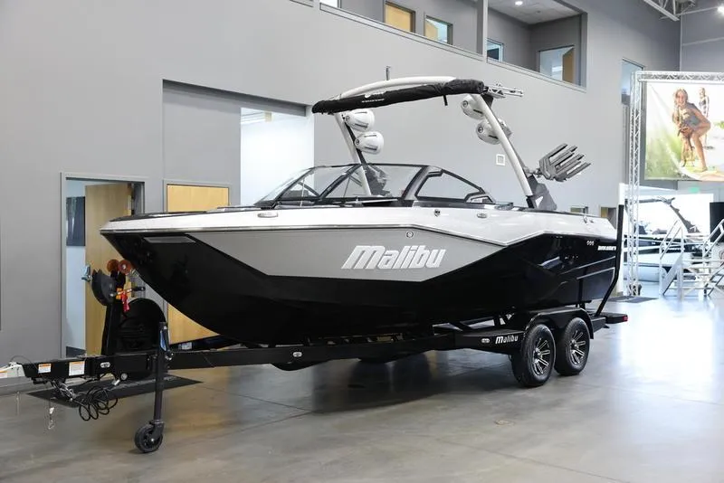 Slide: The Image of 2024 Malibu 22 LSV boat in showroom, black and silver design, on trailer. - 3