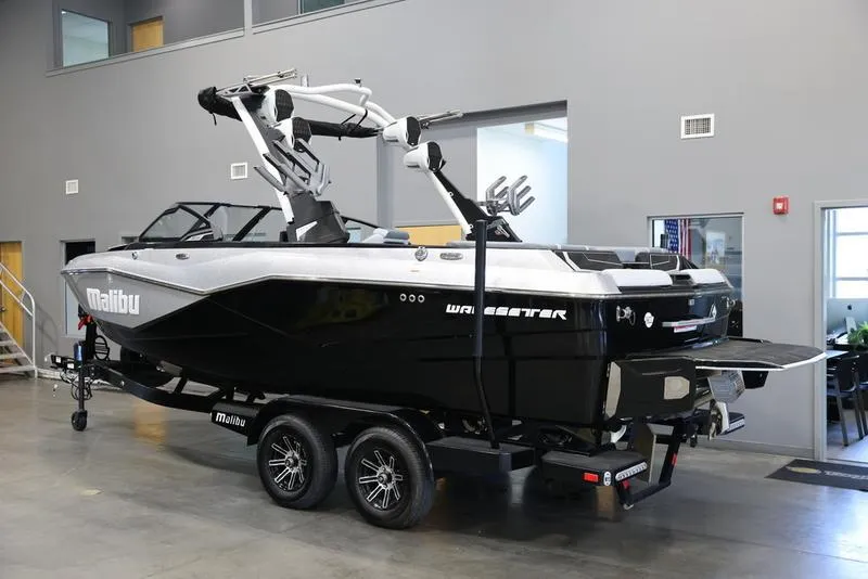 Slide: The Image of 2024 Malibu 22 LSV boat in showroom, black and white design, on trailer. - 4