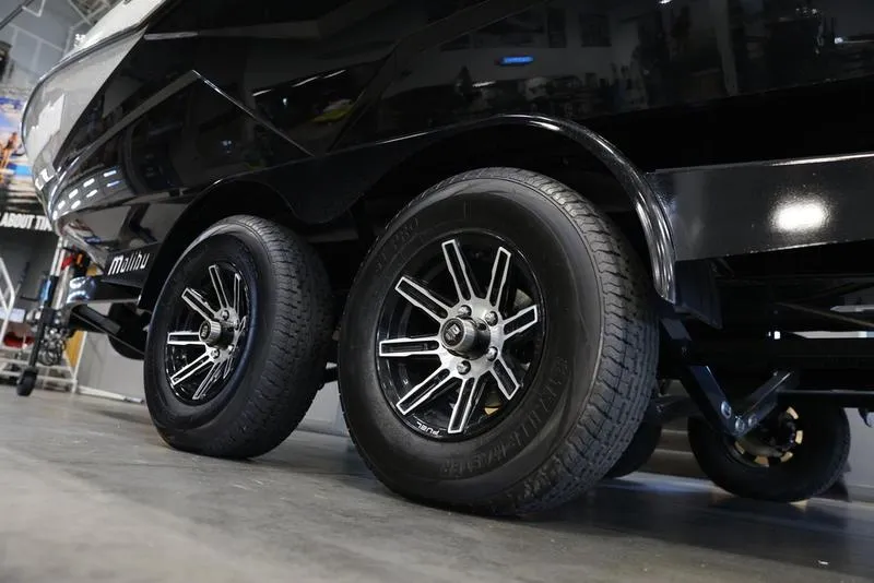 Slide: The Image of 2024 Malibu 22 LSV boat trailer with dual black alloy wheels in a showroom. - 7