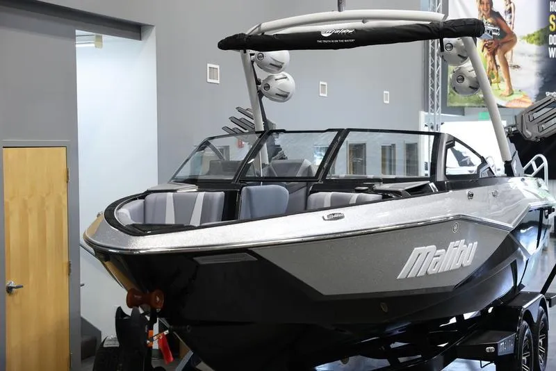 Slide: The Image of 2024 Malibu 22 LSV boat in showroom, sleek design with modern features. - 8