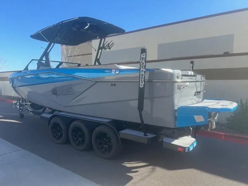 Slide: The Image of 2024 Axis T250 boat on trailer, blue and gray design, parked outdoors. - 4