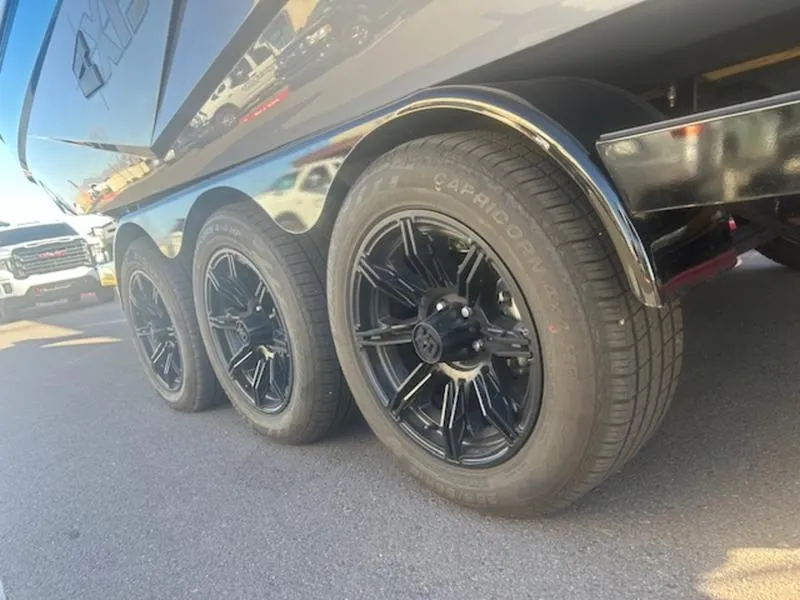 Slide: The Image of 2024 Axis T250 trailer with triple black wheels on a sunny day. - 6