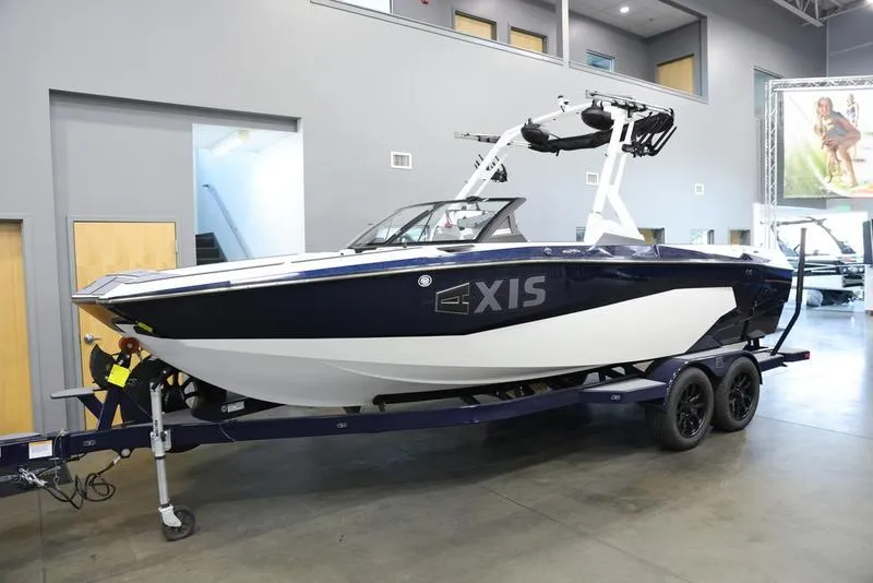 Slide: The Image of 2024 Axis A225 boat on trailer in showroom, sleek design, modern features. - 21