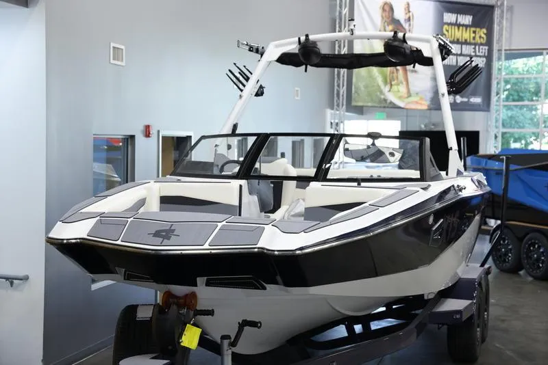 Slide: The Image of 2024 Axis A225 boat displayed indoors on a trailer. - 7