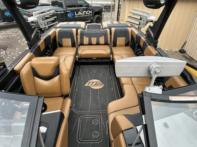 Slide: The Image of 2023 Malibu 23 LSV boat interior with tan and black seating, modern design. - 12