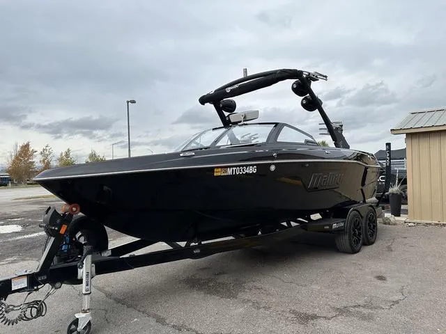Slide: The Image of 2023 Malibu 23 LSV boat on trailer, parked outdoors under cloudy sky. - 3