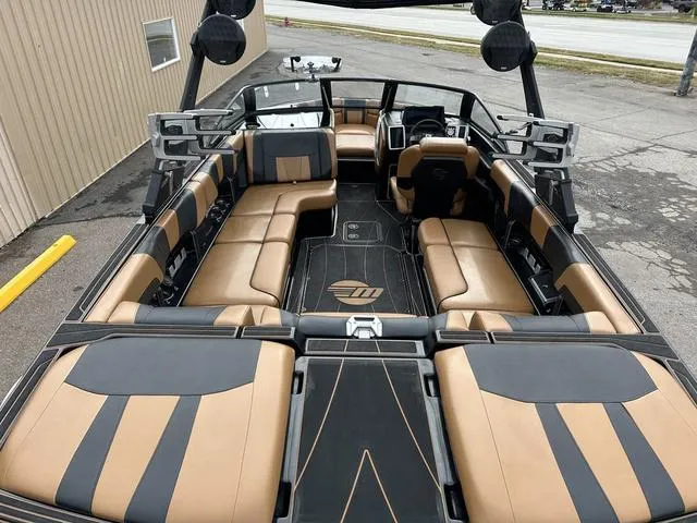 Slide: The Image of 2023 Malibu 23 LSV boat interior with tan and black seating, spacious layout. - 7