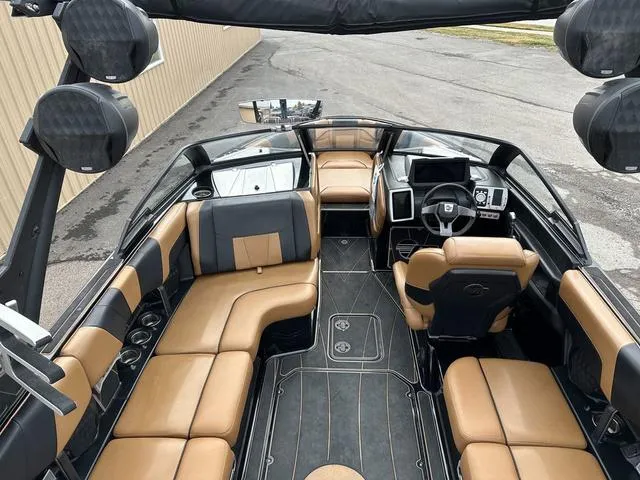 Slide: The Image of 2023 Malibu 23 LSV boat interior with tan and black seating, advanced dashboard controls. - 9