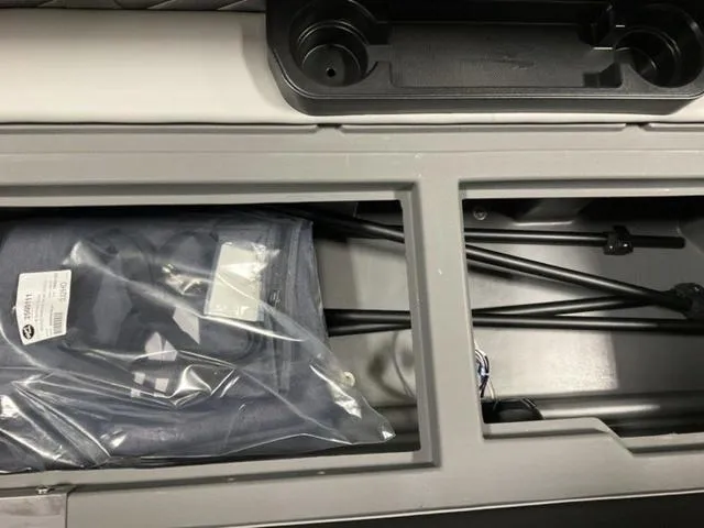 Slide: The Image of 2025 Bennington 23 SSB storage compartment with accessories and cup holders. - 12