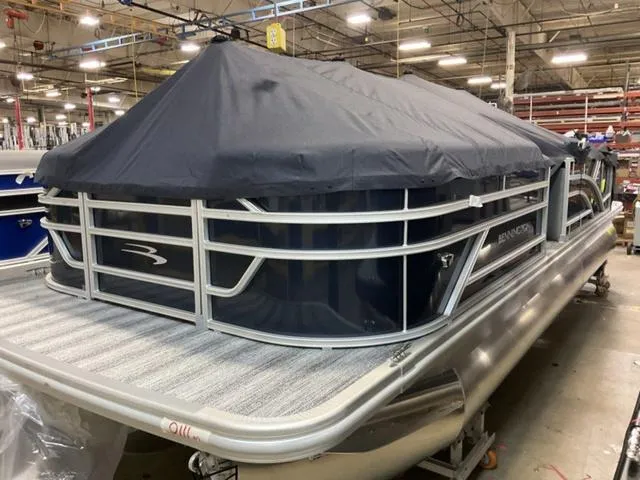 Slide: The Image of 2025 Bennington 23 SSB pontoon boat with cover in a warehouse setting. - 15