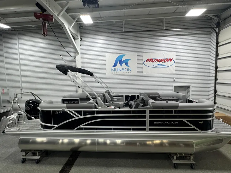 Slide: The Image of 2025 Bennington 22 SSR pontoon boat in showroom, featuring sleek design and modern seating. - 1