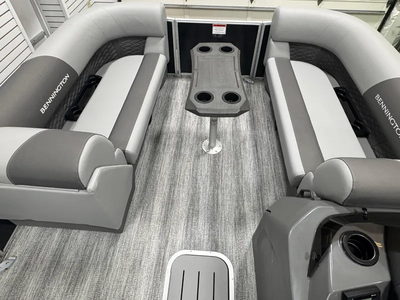 Slide: The Image of 2025 Bennington 22 SSR boat interior with gray seating and central table. - 2