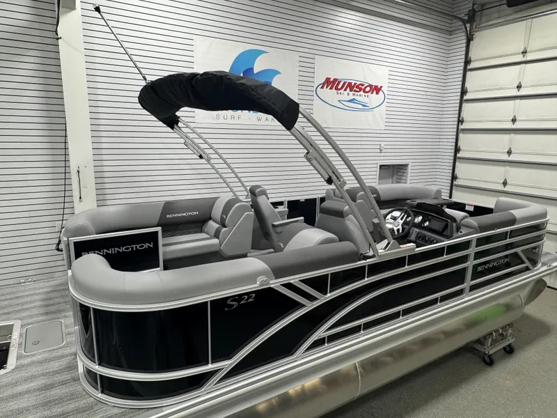 Slide: The Image of 2025 Bennington 22 SSR pontoon boat in showroom, featuring sleek design and modern seating. - 7