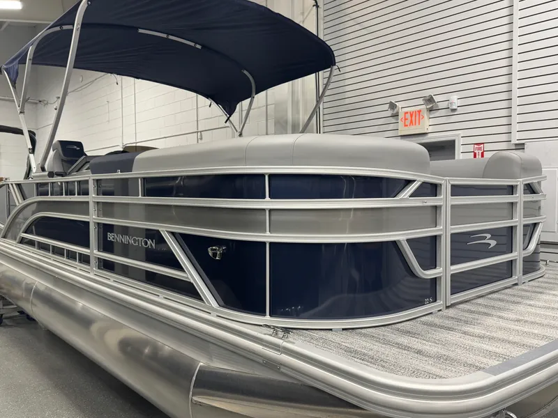 Slide: The Image of 2025 Bennington 22 SSB pontoon boat with canopy in indoor showroom. - 5