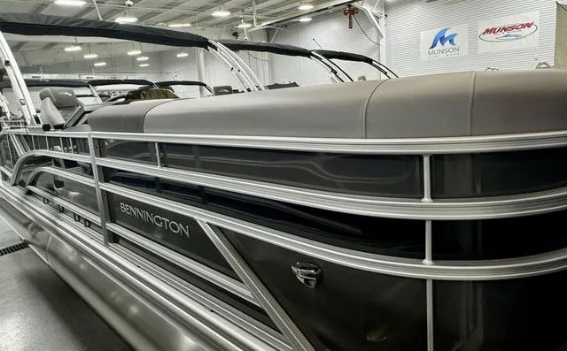 Slide: The Image of 2025 Bennington 22 SSB pontoon boat in showroom, sleek design, Munson Marine signage. - 1