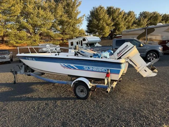 Slide: The Image of 1990 Sunbird 15SW boat with Johnson outboard motor on trailer, parked outdoors. - 3