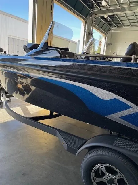Slide: The Image of 2025 Nitro ZV19 boat with sleek black and blue design in a garage setting. - 4