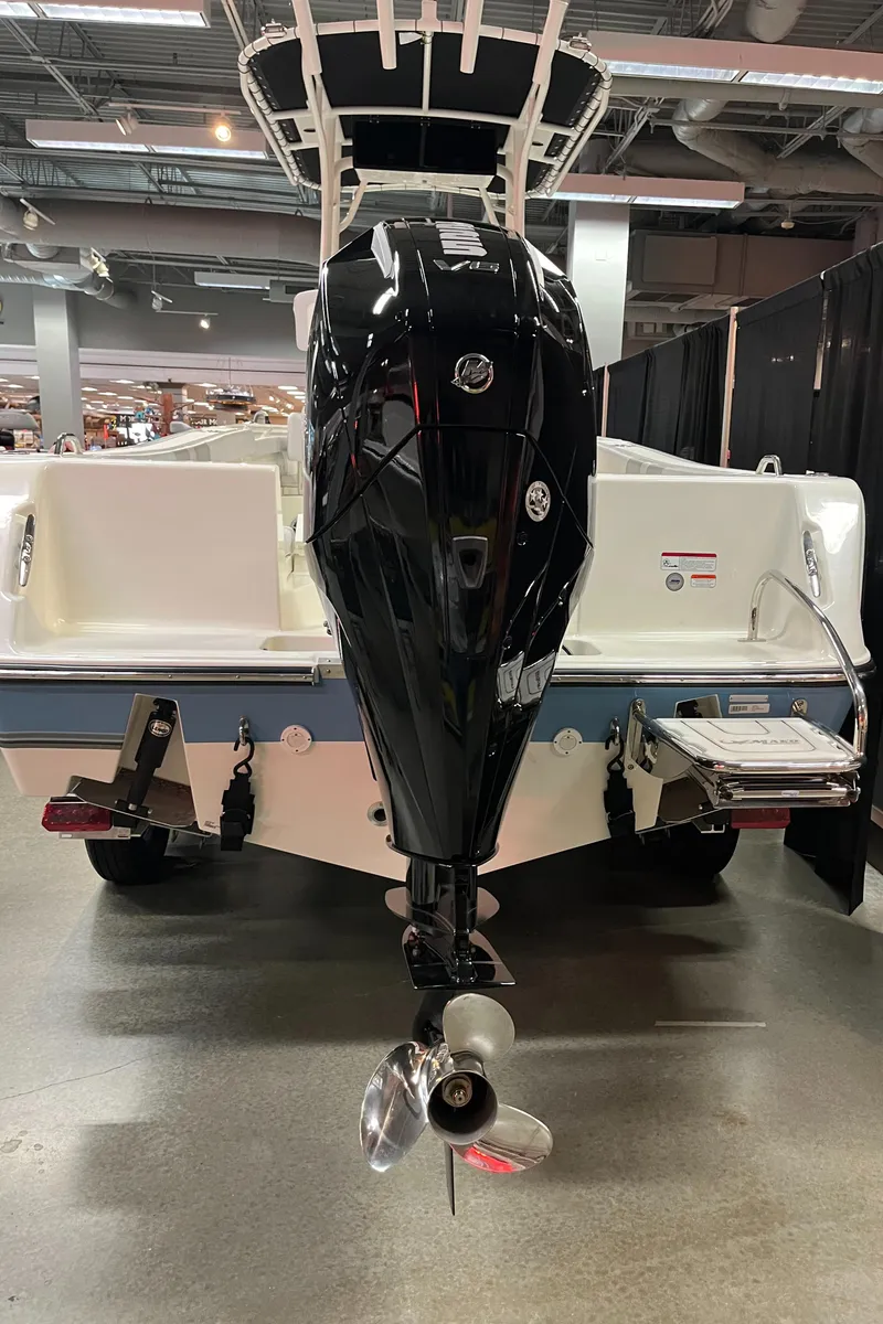 Slide: The Image of 2025 Mako 214 CC boat with powerful outboard motor, showcased indoors. - 4
