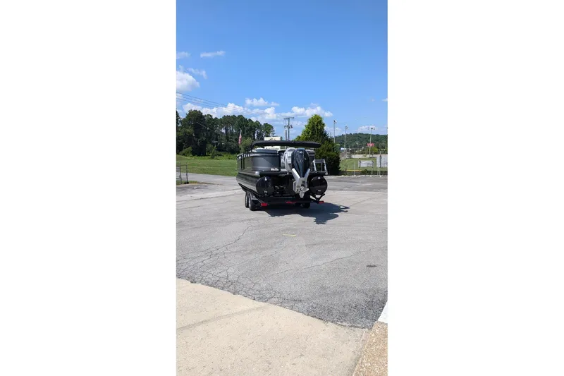 Slide: The Image of 2025 Regency 250 LE3 boat on trailer in parking lot under clear blue sky. - 6