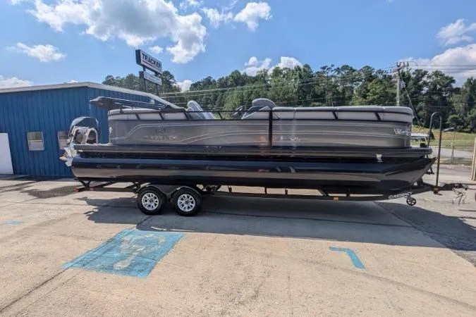 Slide: The Image of 2025 Regency 250 LE3 pontoon boat on trailer, parked outside dealership. - 7