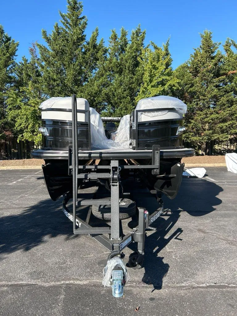 Slide: The Image of 2025 Regency 250 LE3 boat on trailer, parked outdoors with trees in background. - 2