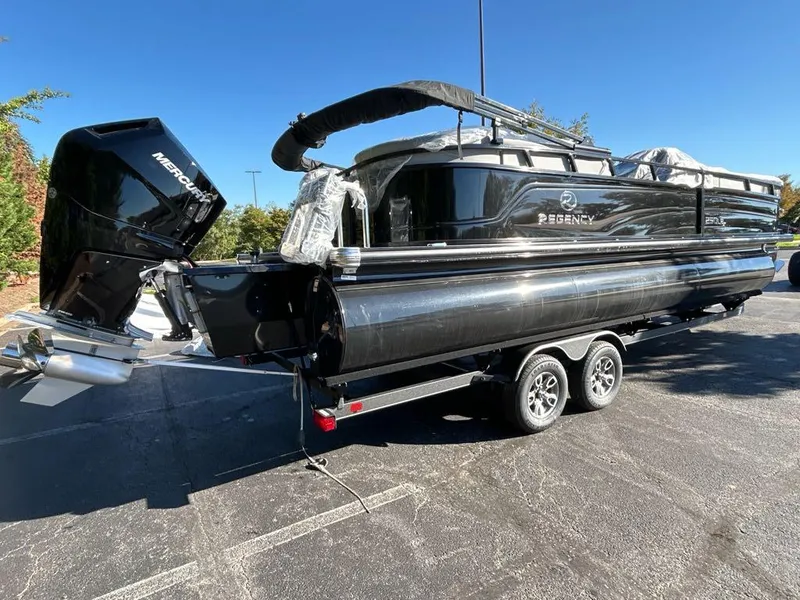Slide: The Image of 2025 Regency 250 LE3 pontoon boat on trailer, black exterior, parked outdoors. - 3