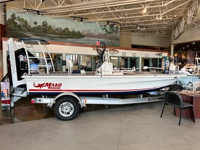 Slide: The Image of 2025 Mako 18 Pro Skiff Patriot Edition displayed in a showroom on a trailer. - 0