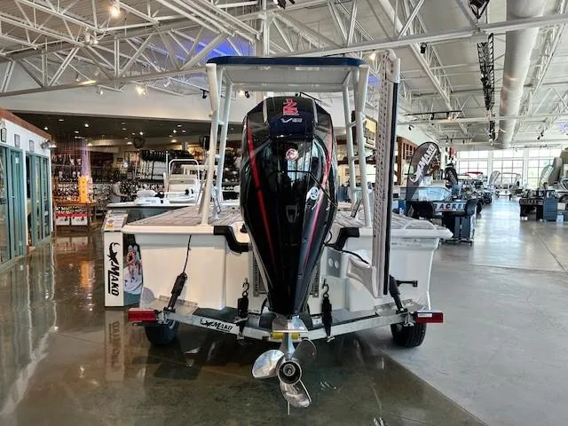 Slide: The Image of 2025 Mako 18 Pro Skiff Patriot Edition boat displayed in a showroom. - 2