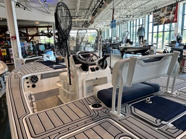 Slide: The Image of 2025 Mako 18 Pro Skiff Patriot Edition in showroom, featuring modern design and spacious deck. - 3