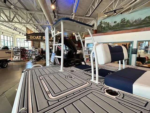 Slide: The Image of 2025 Mako 18 Pro Skiff Patriot Edition displayed in a boat showroom. - 4