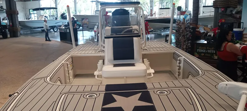 Slide: The Image of 2025 Mako 18 Pro Skiff Patriot Edition boat on display indoors. - 3