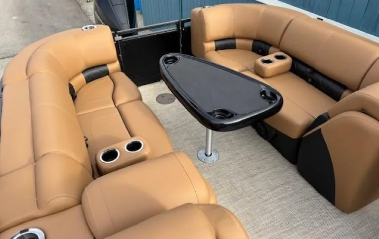 Slide: The Image of 2025 Regency 230 LE3 boat interior with tan seating and black table. - 12