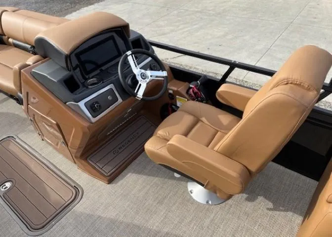 Slide: The Image of 2025 Regency 230 LE3 boat interior with tan leather seats and modern dashboard. - 8