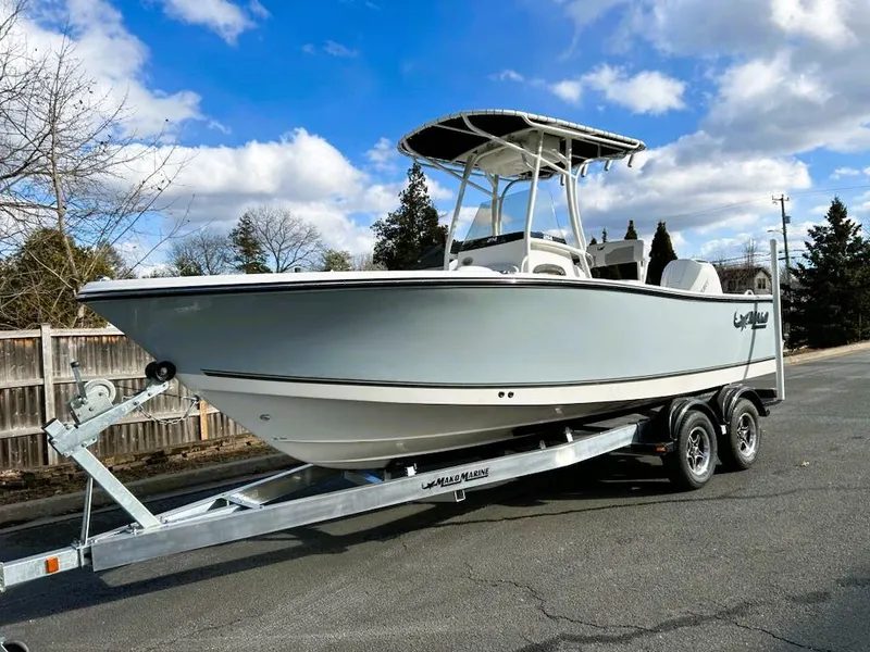 The Image of 2025 Mako 214 CC boat on trailer under blue sky with clouds. - 0