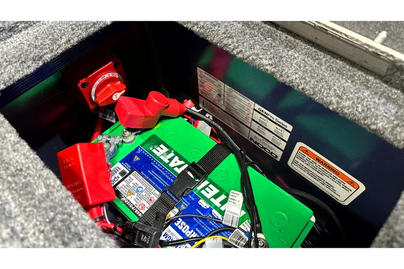 Slide: The Image of Battery compartment of 2025 Tracker Targa V-19 WT with visible wiring and safety labels. - 18