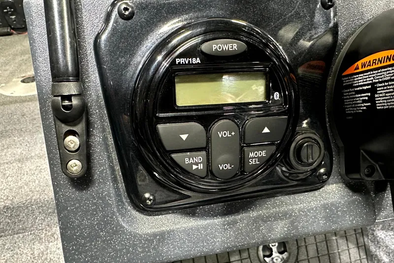 Slide: The Image of 2025 Tracker Targa V-19 WT boat control panel with audio system and warning label. - 22