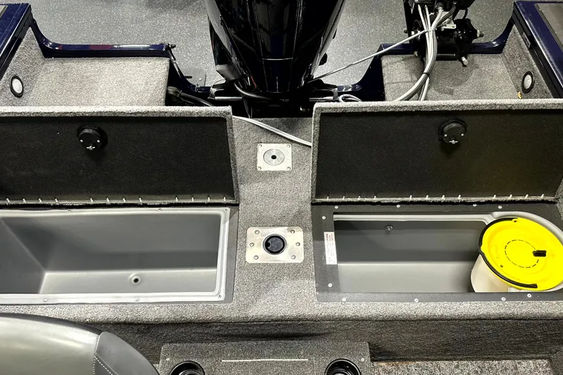Slide: The Image of 2025 Tracker Targa V-19 WT boat interior with open storage compartments and motor cables. - 26