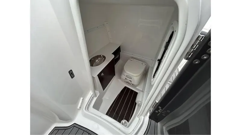 Slide: The Image of 2018 Monterey M65 boat interior with compact bathroom, featuring a toilet and sink. - 16