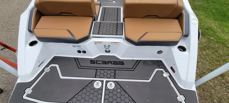 Slide: The Image of 2021 Scarab 215 ID boat with tan seats and black deck, viewed from above. - 10